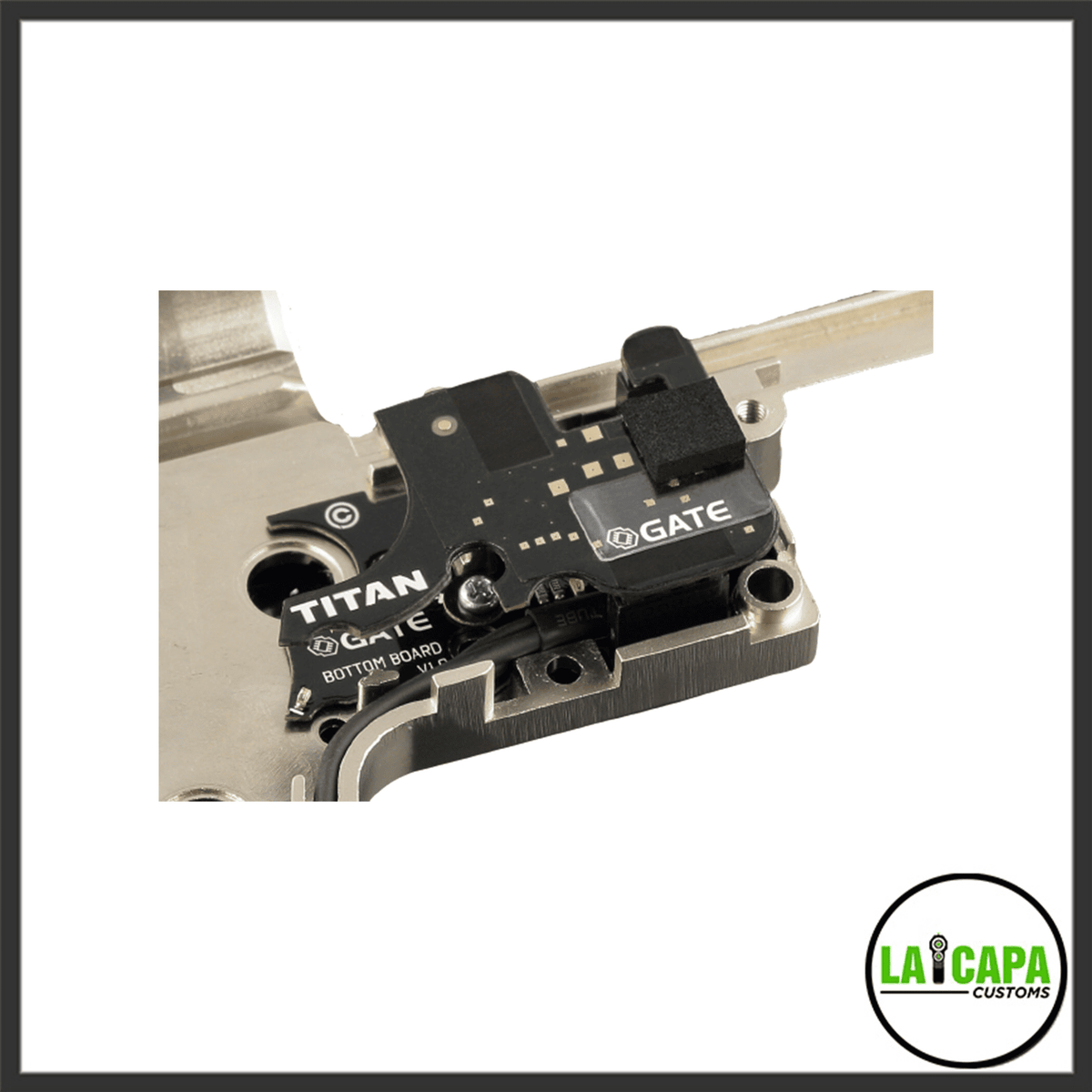 Gate Titan V2 bottom board and optical sensor module seated inside an open airsoft gearbox shell, viewed from above at an angle.