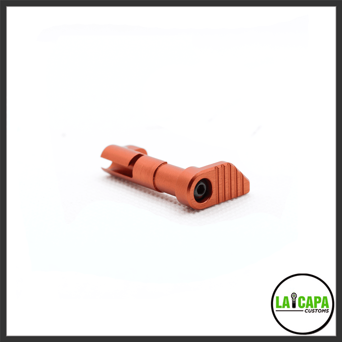 LA Capa Customs Magazine Catch in orange, shown at an angle revealing the ribbed paddle and retention screw.