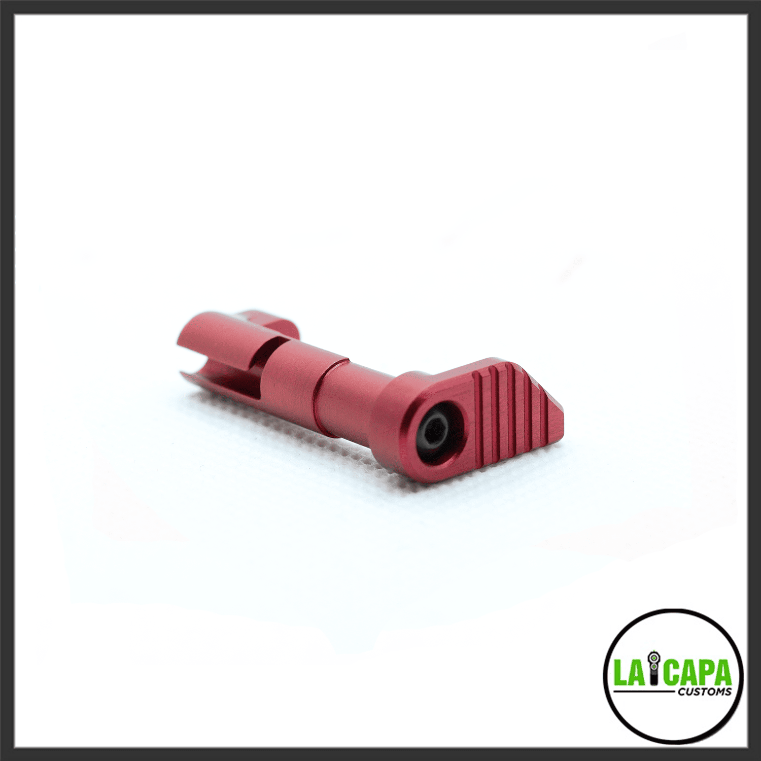 LA Capa Customs magazine catch in red anodized aluminium, showing the ribbed paddle and pin detail against a white background.