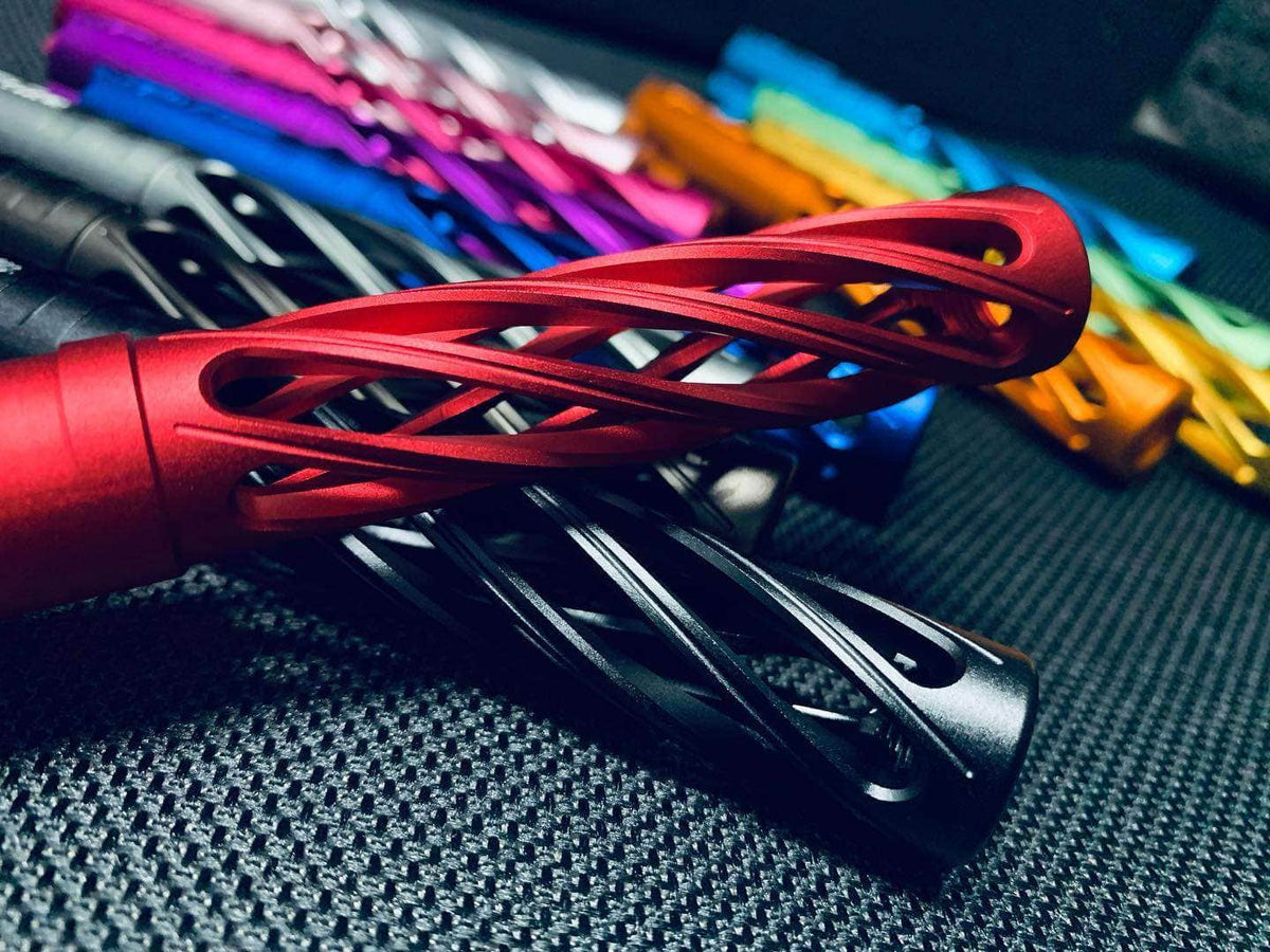 Dr. Black super hollow aluminum outer barrels piled together, with a red twisted open-lattice barrel and a black spiral-cut barrel in the foreground and multiple colours visible behind.