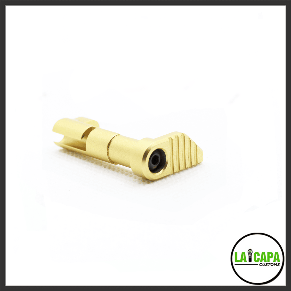 LA Capa Customs magazine catch in gold finish, showing ribbed thumb paddle and retention pin, isolated on white.