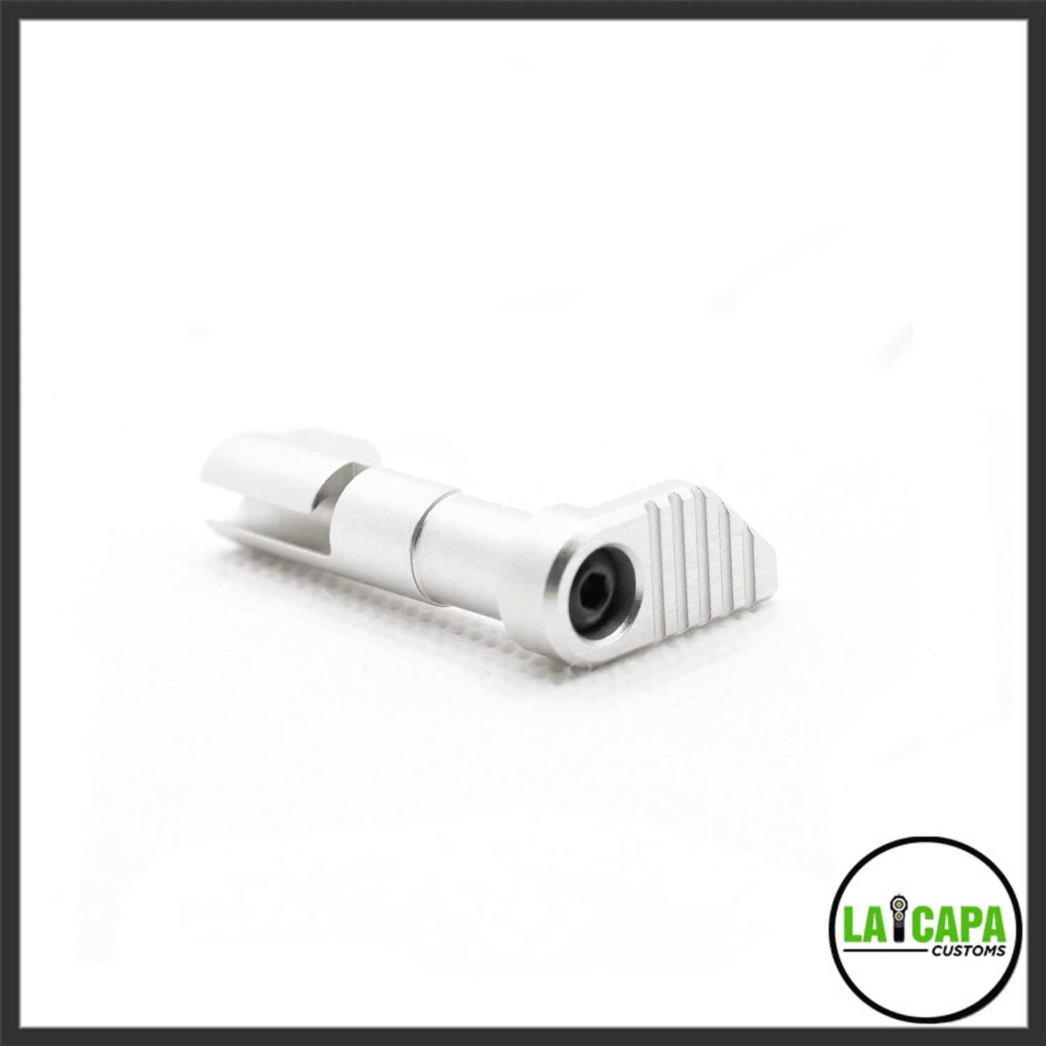 LA Capa Customs magazine catch in silver, showing the ribbed paddle face and retention pin, angled view.