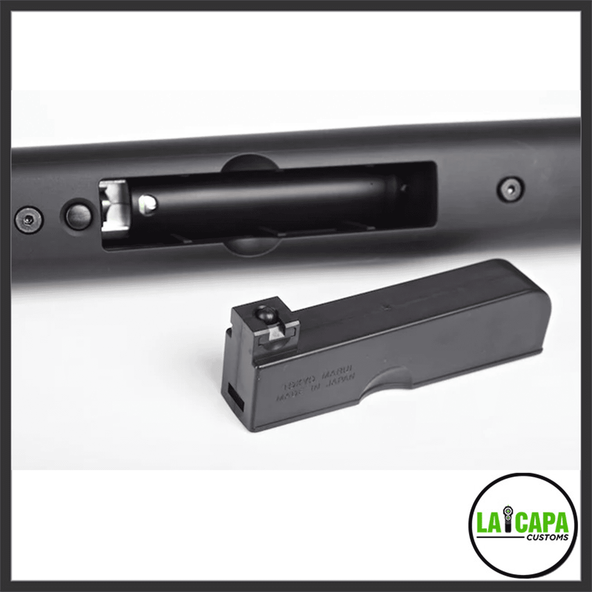 Tokyo Marui VSR-10 G-Spec magazine well open with the detached box magazine placed in front of the stock.